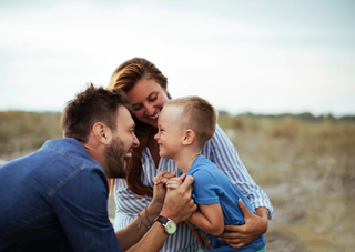Fröhliche Familie spielt im Freien, fördert Bindung und Kindererziehung.