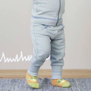 Baby trägt hellblaue Bio-Baumwoll-Krabbelhose "Froggy" von Living Crafts mit Froschsocken.